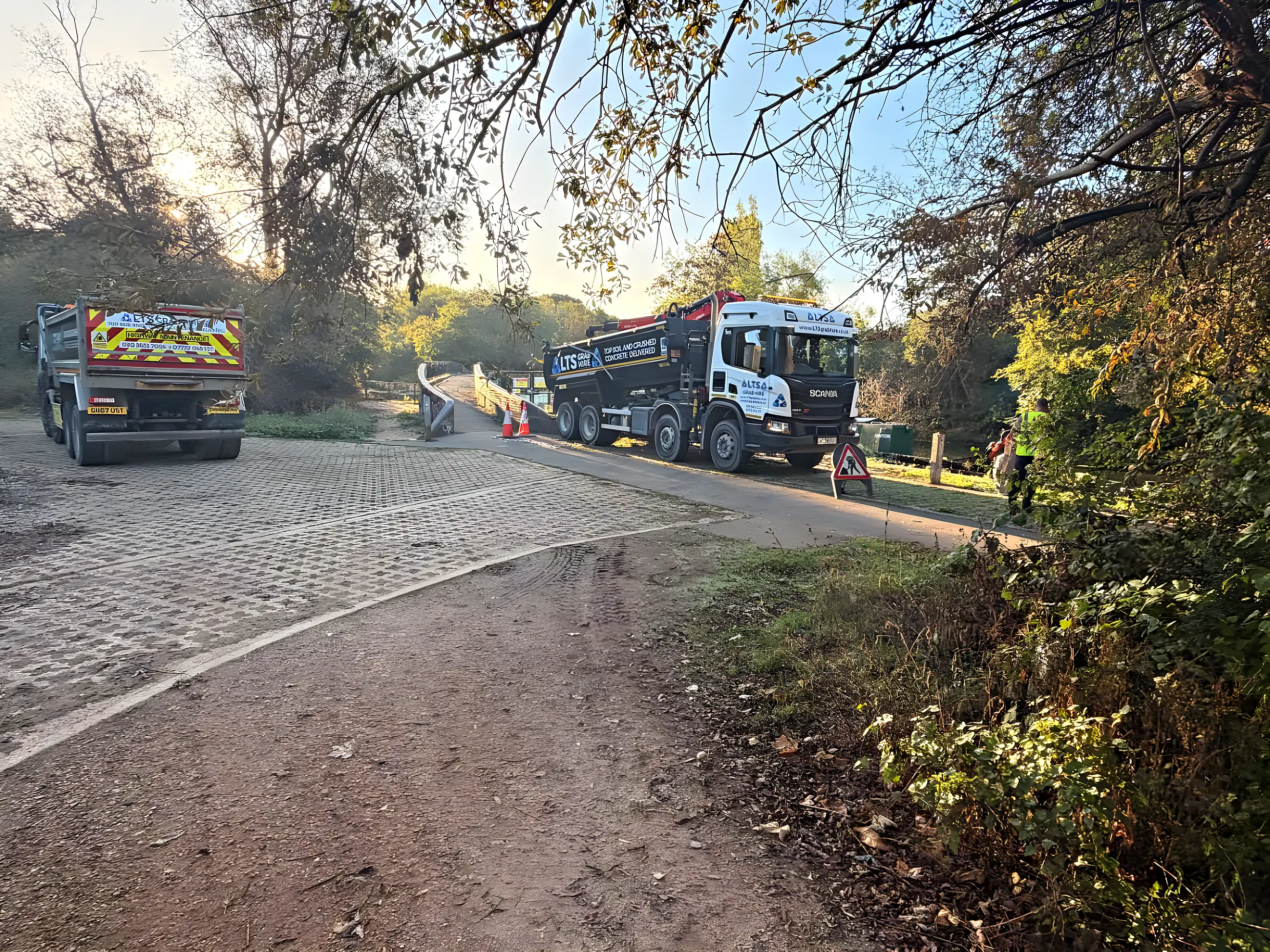 Two of our lorries on the same riverside job in autumn sunshine